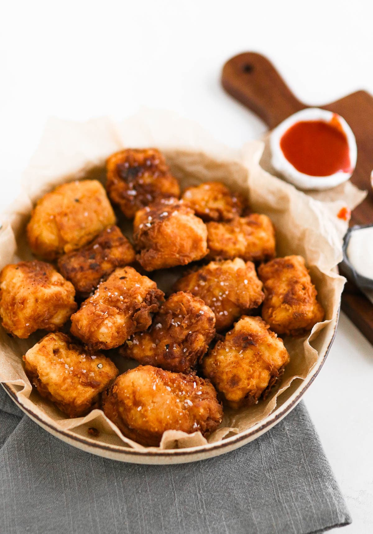 chicken-fried tofu nuggets in a bowl with ketchup in the background
