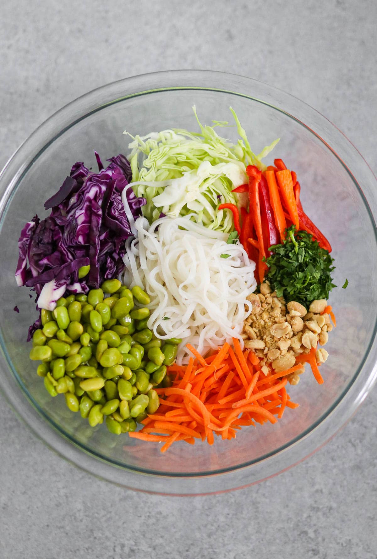 Photo of noodles and ingredients before combining in a glass bowl.