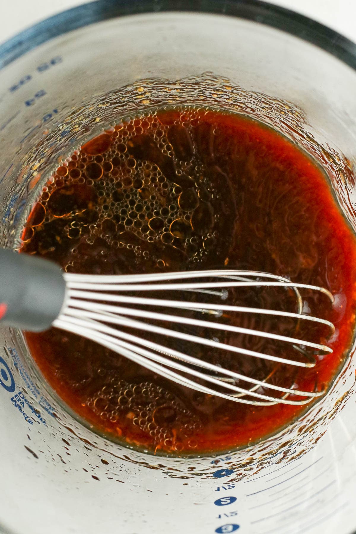 Whisked sauce in a glass measuring cup.
