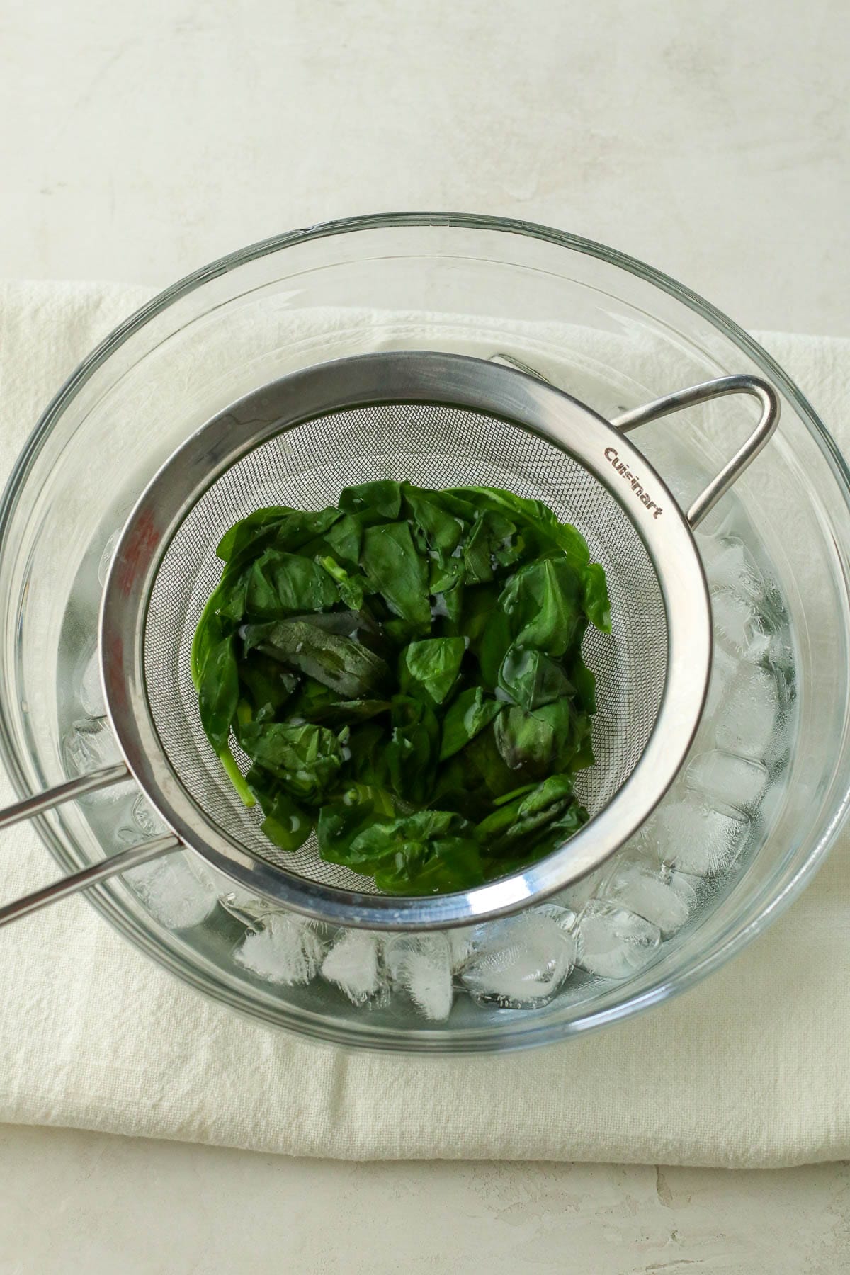 cooked basil going into ice bath.