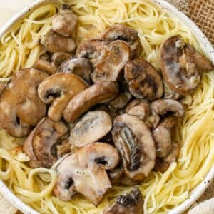 mushroom sauce on top of pasta in a white bowl.