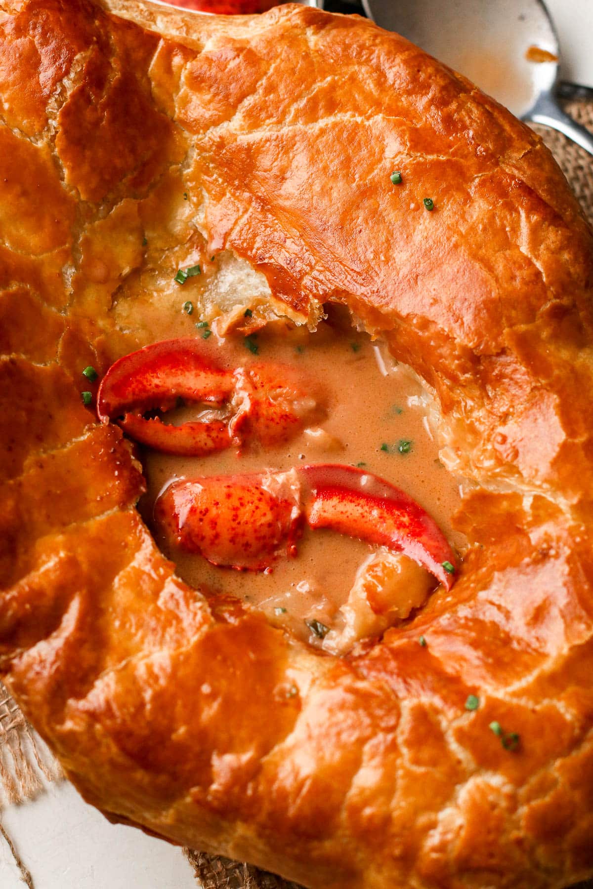 pot pie broken into with lobster claws exposed.
