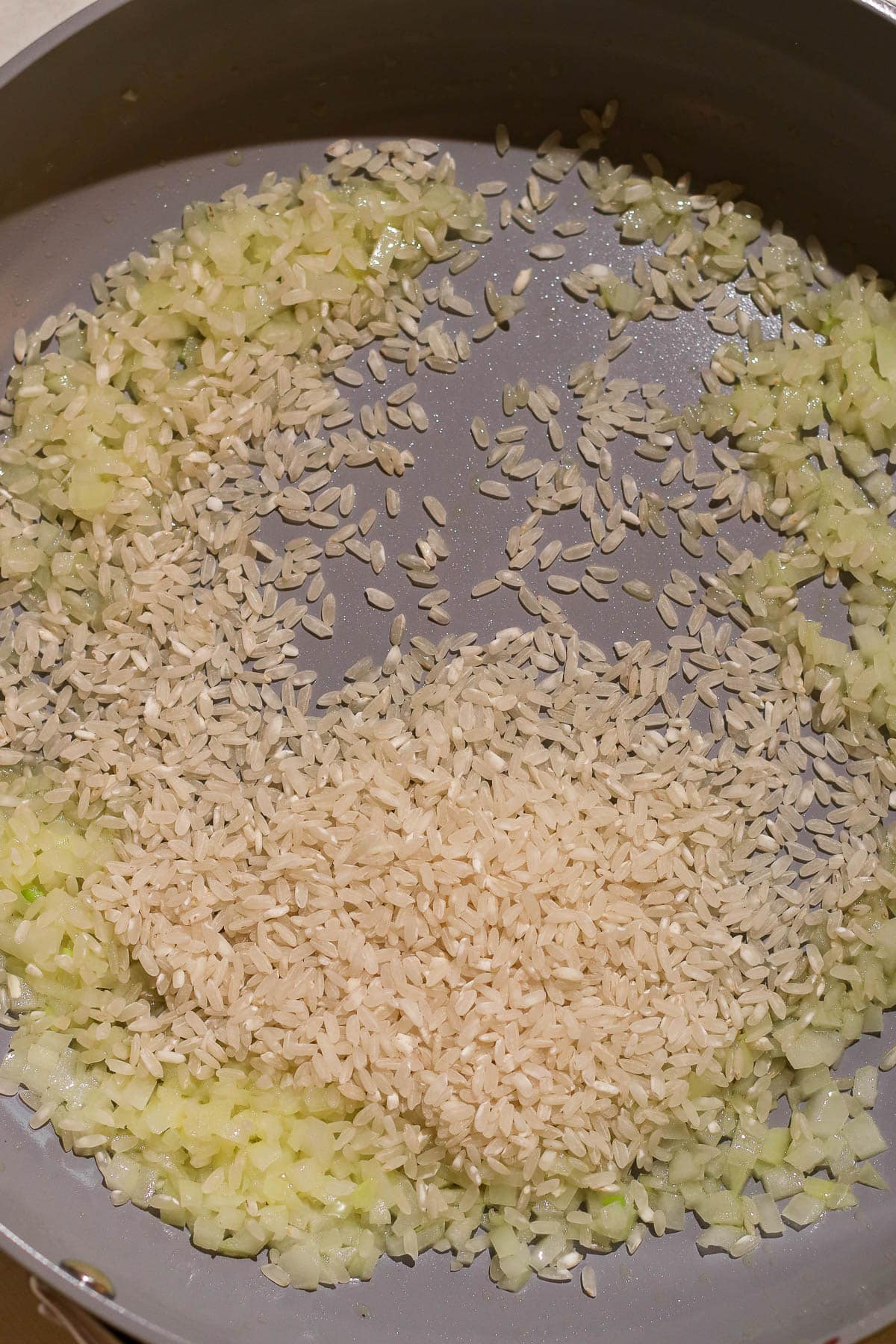 rice and onion in a pan.