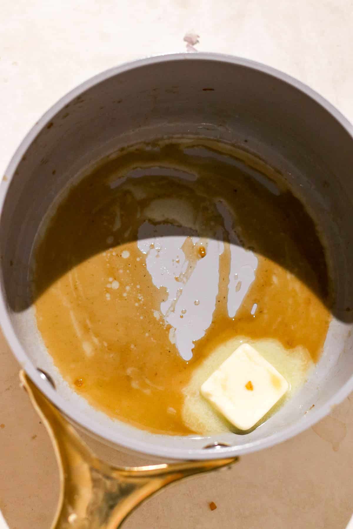 brown liquid and butter in pot.