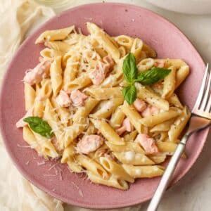 salmon pasta on a pink plate.